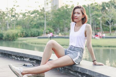 Women sitting on the bridge in the parkの写真素材