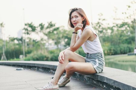 Women sitting on the bridge in the parkの写真素材