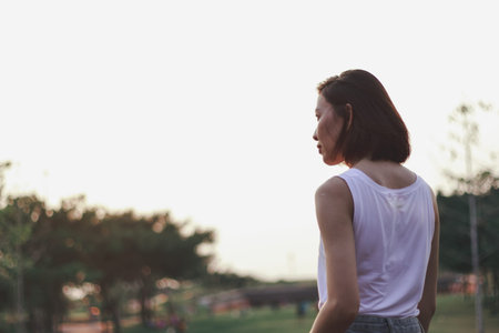 The back of the woman standing at sunset