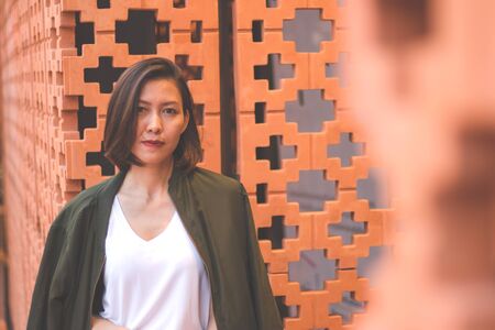Women are standing against the brick wall and looking atの写真素材