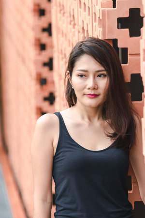 Women are standing against old brick walls.の写真素材