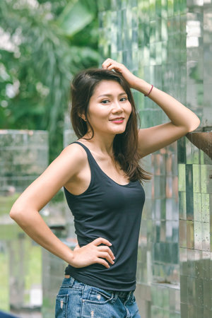Woman standing against a wall with a mirror