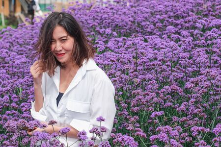 Women in the Verbena field are blooming and beautiful in the rainy season.の写真素材