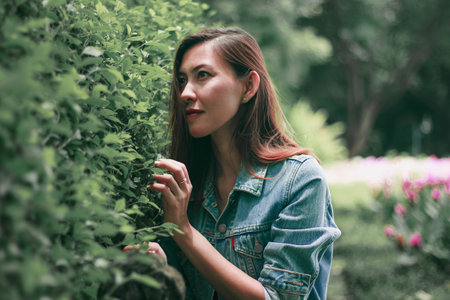 A long haired woman standing against a tree wall