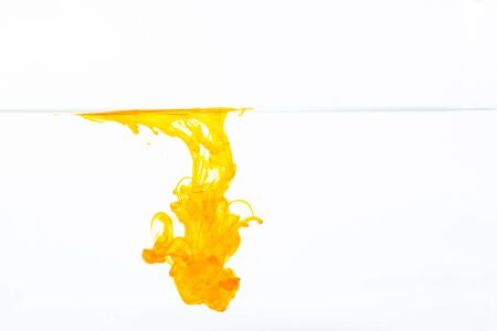 Orange ink drop in water, abstract orange ink in water on white backgroundの写真素材