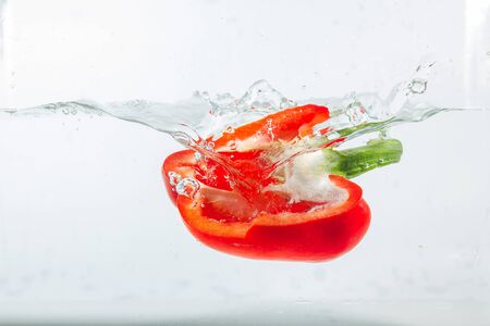 Sweet pepper in water splashes, red sweet pepper on a white background. Sweet peppers are a type of pepper. Not spicyの写真素材