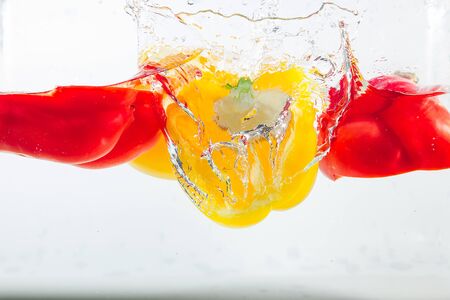 Sweet pepper in the yellow, red, green splashes of water, Sweet pepper is on a white background. Sweet peppers are a type of pepper. Not spicyの写真素材