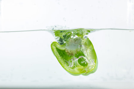 Sweet pepper in water splashes, green sweet pepper on a white background. Sweet peppers are a type of pepper. Not spicyの写真素材