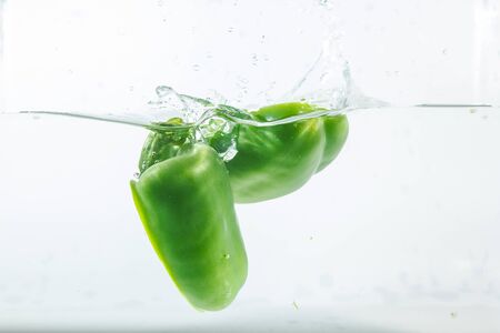Sweet pepper in water splashes, green sweet pepper on a white background. Sweet peppers are a type of pepper. Not spicyの写真素材
