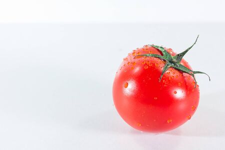 Water drops on tomatoes On a white background, when ripe tomatoes are red or orange, Tomatoes for cooking and eating fresh fruitの写真素材