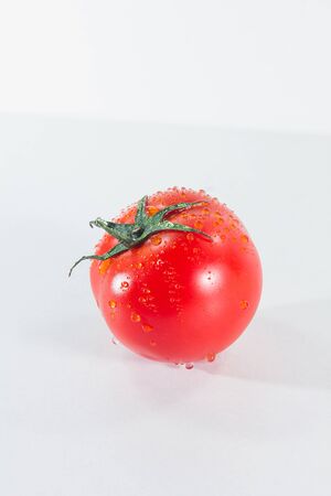 Water drops on tomatoes On a white background, when ripe tomatoes are red or orange, Tomatoes for cooking and eating fresh fruitの写真素材