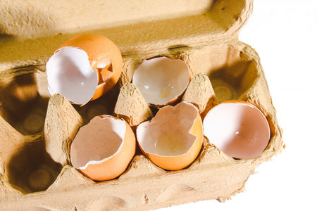 Broken egg isolated on white background, broken egg shell from impact