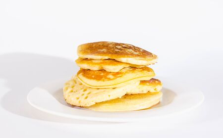 pancakes are stacked on a white plate. On a white backgroundの写真素材