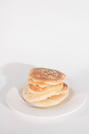 pancakes are stacked on a white plate. On a white backgroundの写真素材