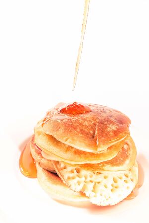 pancakes stacked on a white plate , The pancakes are topped with honeyの写真素材