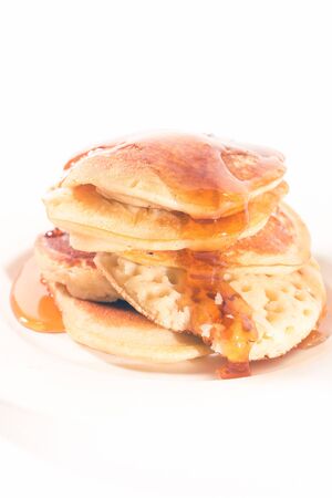 pancakes stacked on a white plate , The pancakes are topped with honeyの写真素材
