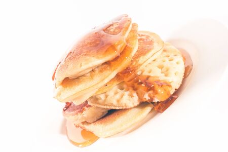pancakes stacked on a white plate , The pancakes are topped with honeyの写真素材