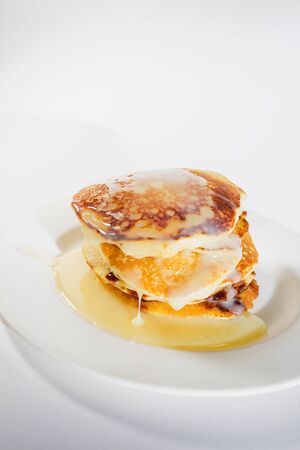 pancakes stacked on a white plate,
Pancakes are topped with sweetened condensed milk.の写真素材