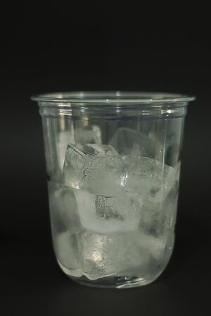 Ice cubes in plastic glasses on a black backgroundの写真素材