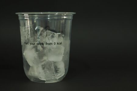 Ice cubes in plastic glasses on a black backgroundの写真素材