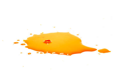 Orange water droplets splashing on a white backgroundの写真素材