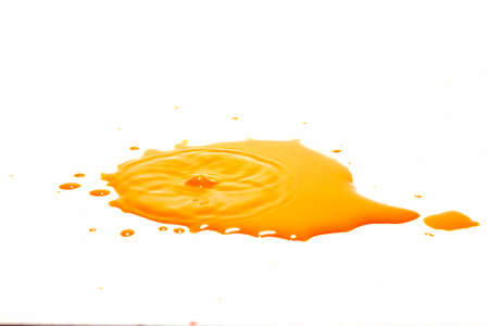 Orange water droplets splashing on a white backgroundの写真素材