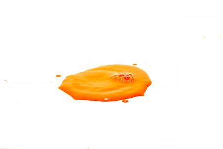 Orange water droplets splashing on a white background
