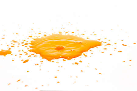 Orange water droplets splashing on a white backgroundの写真素材