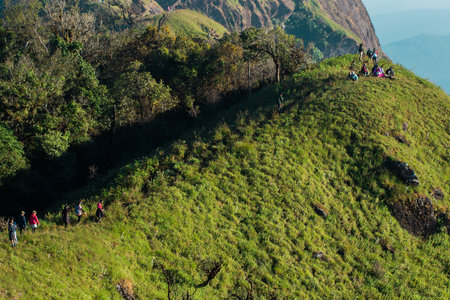 Tourists walk on a high hill to see the scenery on the mountain.の写真素材