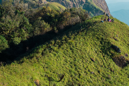 Tourists walk on a high hill to see the scenery on the mountain.の写真素材