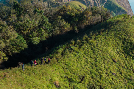Tourists walk on a high hill to see the scenery on the mountain.の写真素材