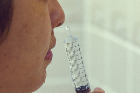 Using a syringe containing saline to rinse your nose thoroughly.の写真素材