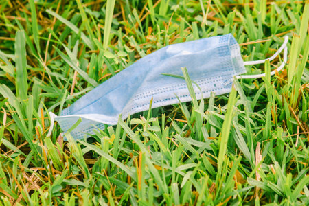 The disposable medical masks were thrown as garbage on the grass.