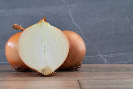 Photo of onions on wooden and stone background.の写真素材