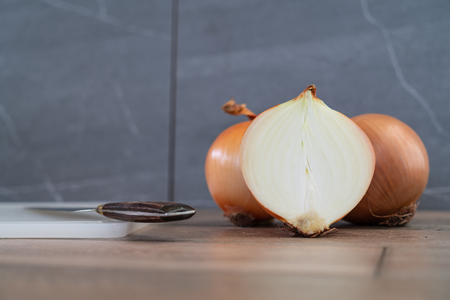 Photo of onions on wooden and stone background.の写真素材