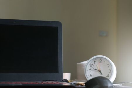 The clock placed on the working deskの写真素材