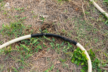 An old hose that leaks and is fixed by wrapping it with a rubber band.の写真素材