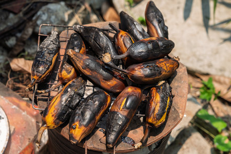 Grilled bananas are placed on a grill over a charcoal stove.の写真素材