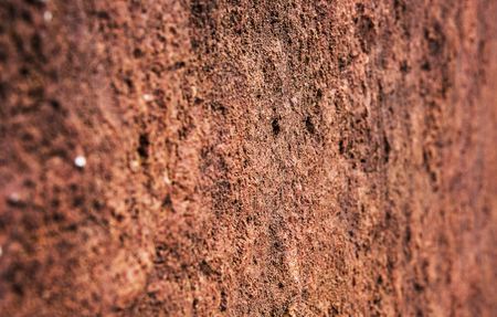 Closeup red stone wall texture background. Angle view.の写真素材