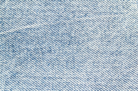 Closeup light blue jeans denim textile texture background.
