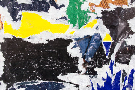 Dirty ripped and peeling magazine paper posters. Grungy street billboard with old motley placards...