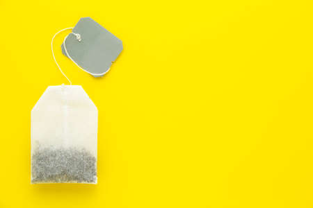 Tea bag with gray blank label on yellow background. Copy space for text.の写真素材