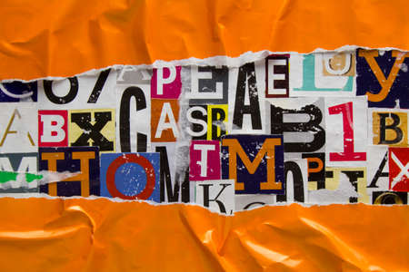 Torn and crumpled orange paper on collage from clippings with newspaper magazine letters and numbers. Ripped orange paper on alphabet letters cutting from magazine. Abstract background.の写真素材