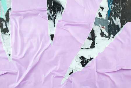 Torn and peeling purple poster glued on billboard with old dirty paper. Abstract and creative background of ripped purple glossy magazine paper.の写真素材