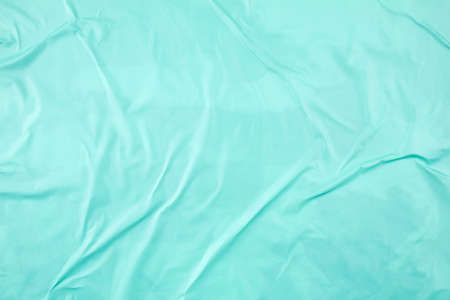 Crumpled juicy azure blue paper poster glued on rough surface. Abstract creative background of glossy wavy magazine paper.の写真素材