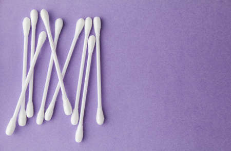 White hygienic cotton buds or cotton swabs on purple paper background. Copy space for text.の写真素材