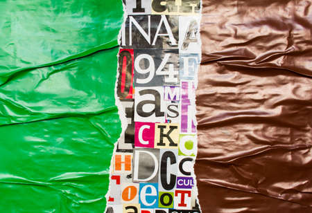 Torn and crumpled green and brown glossy paper poster on bright colorful collage of magazine paper pieces and clippings with letters and numbers background.の写真素材