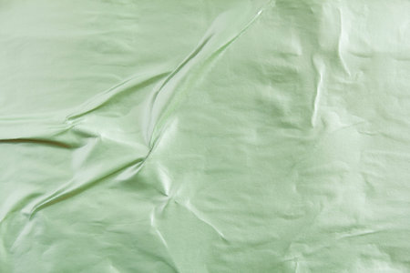 Pale green crumpled gloss paper placard on billboard with rough surface. Green creased paper poster texture background.の写真素材