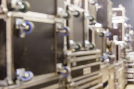 Blurred background of protective flight cases on wheels in warehouse storage zone. Defocused image of backstage with flight cases. Bokeh effect.の写真素材