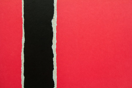 Torn red cardboard on black paper texture background. Copy space for text message.の写真素材
